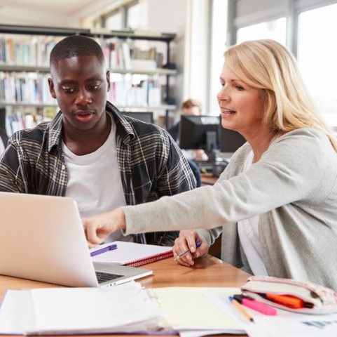 Adviser with student in library 