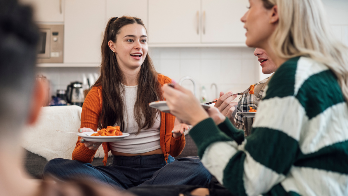 A group of students sat talking in a communal kitchen area