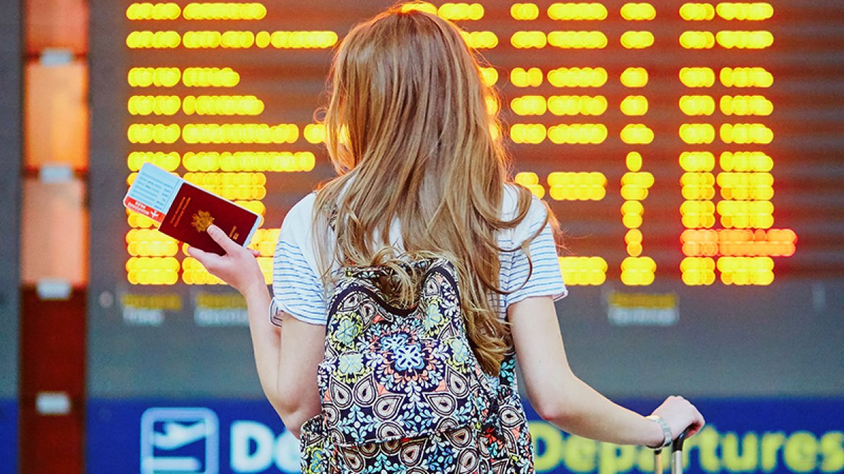 Young woman holding a passport and ticket at an airport