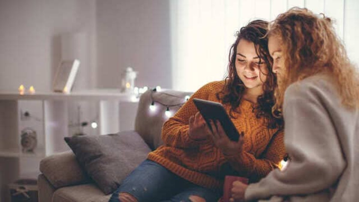 Parent helping child research apprenticeships on tablet