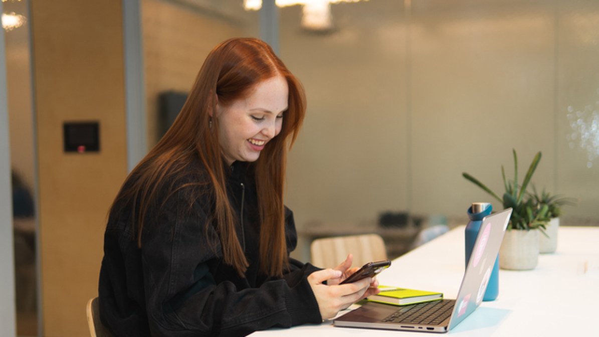 Care experienced apprentice using laptop in the workplace