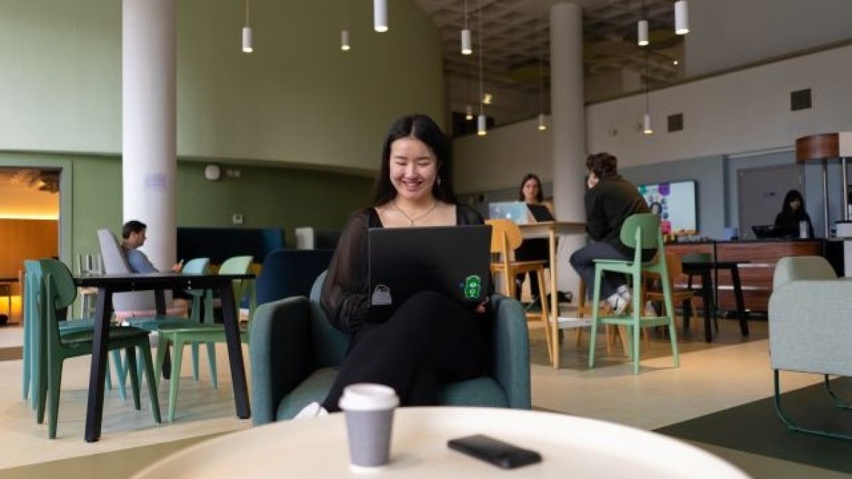 Student using laptop in communal area of university