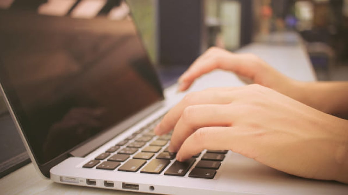 Person's hands using laptop keyboard