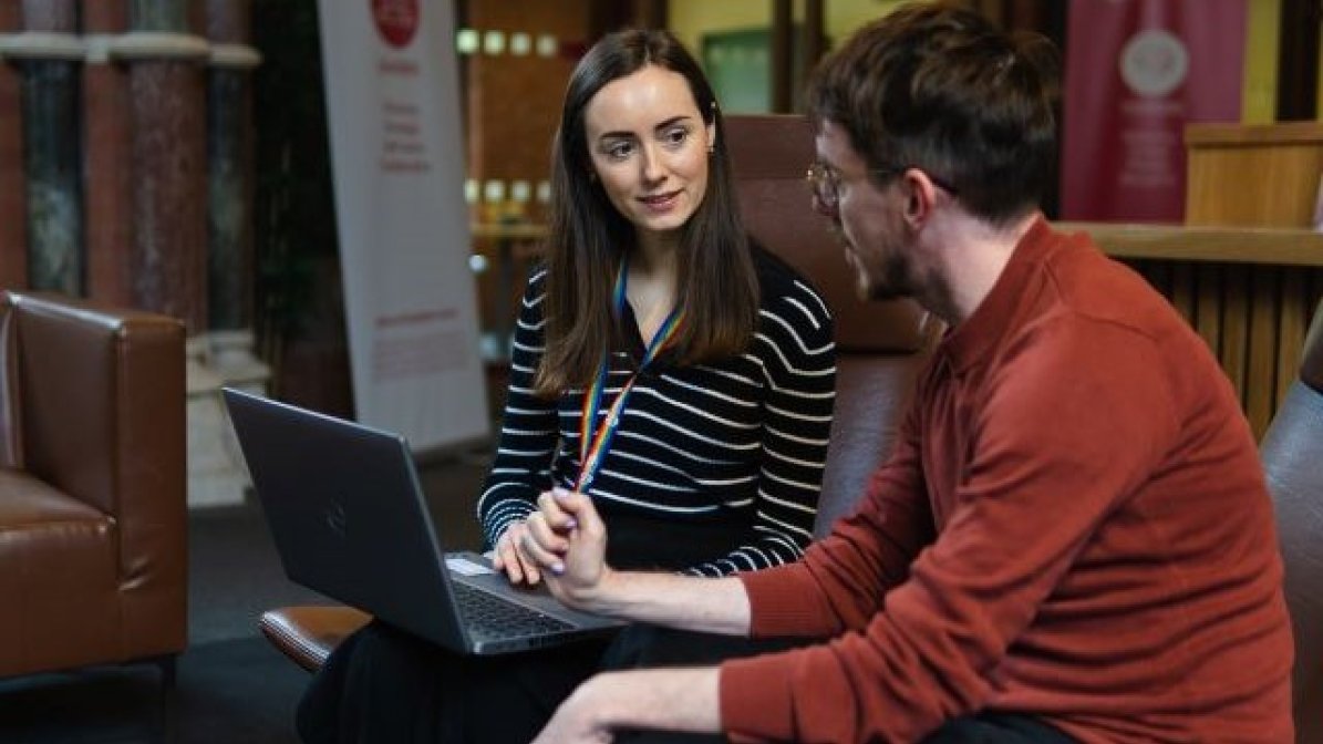 Students using laptop in university communal area