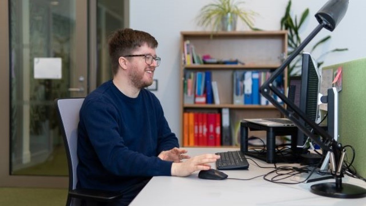 Adviser writing a UCAS reference on computer