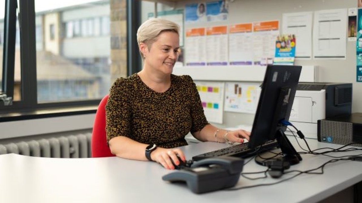 Adviser working on computer at desk
