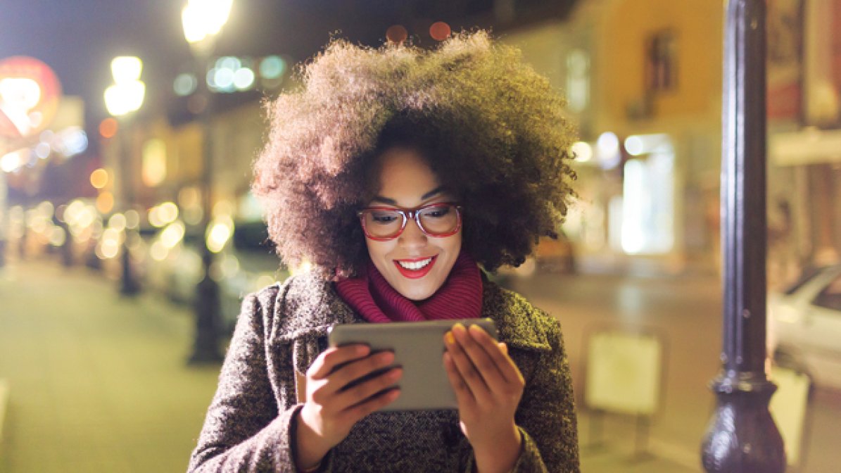 Digital content influencer on street looking at tablet
