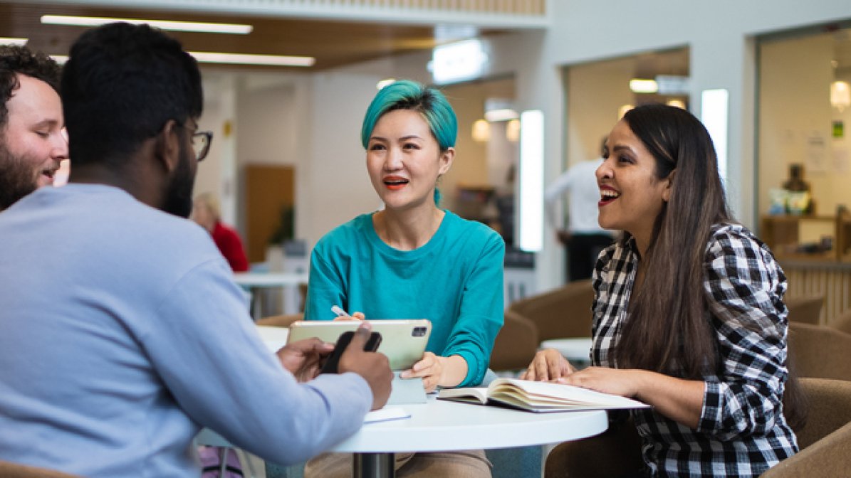 Students chatting at table in uni common room