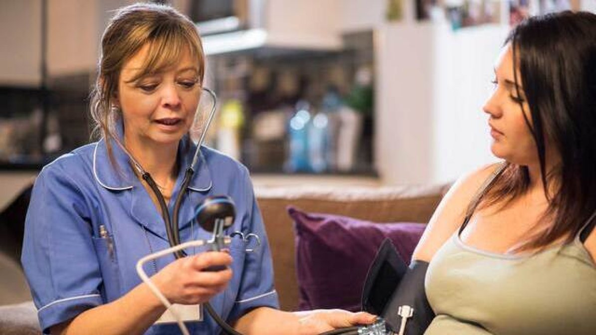 Midwife taking patient's blood pressure
