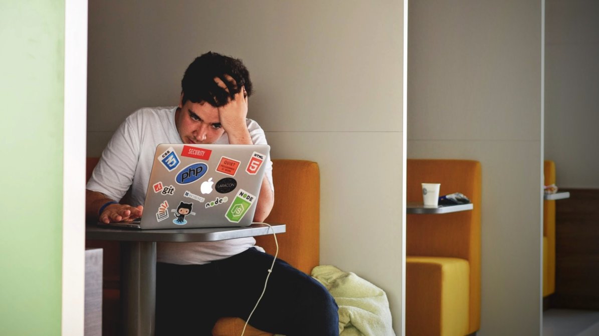 A male student nervously looks at his laptop