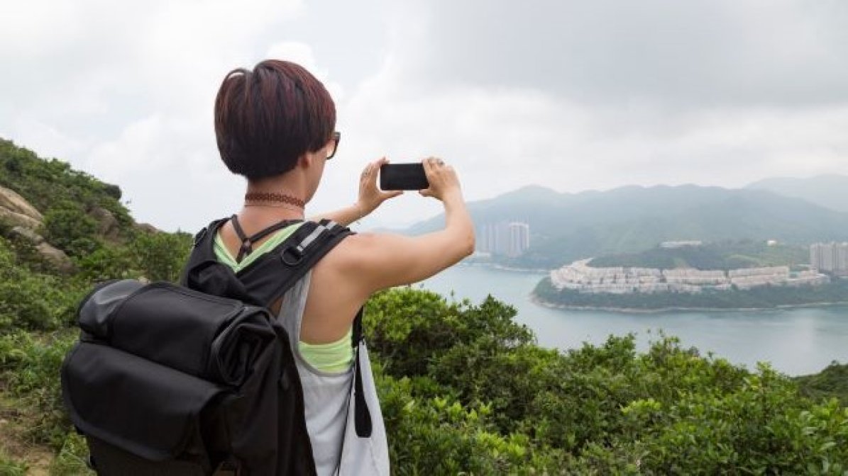 HIstory of art student taking photos from top of a hill on a hike 