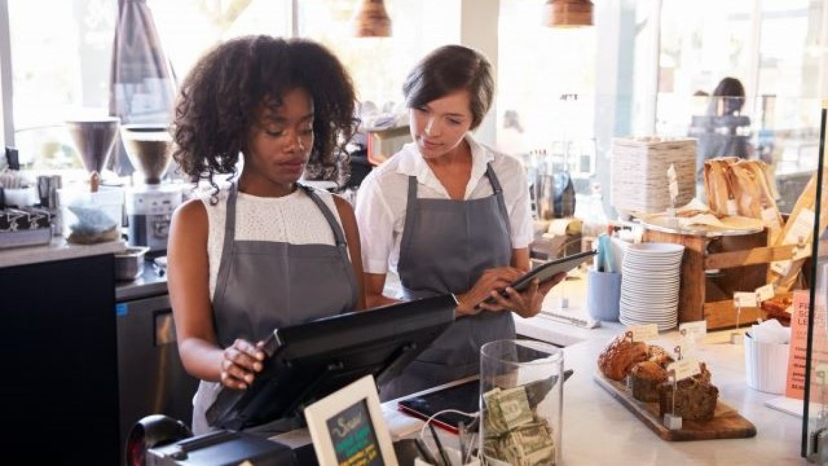 Student working in coffee shop using till