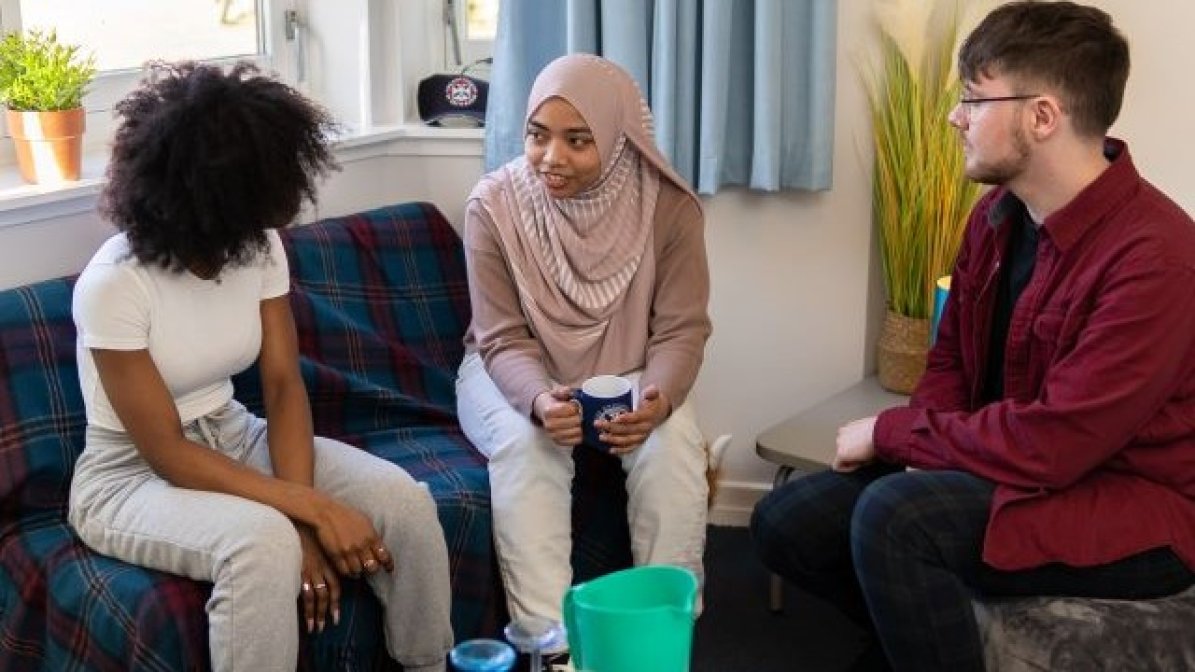 Students chatting in shared accommodation living room