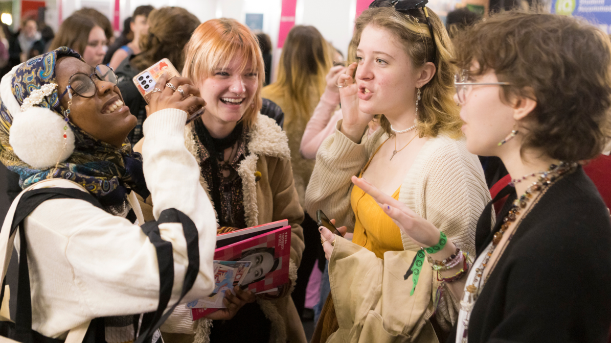 A diverse groupn of students laughing and talking at a UCAS Discovery event