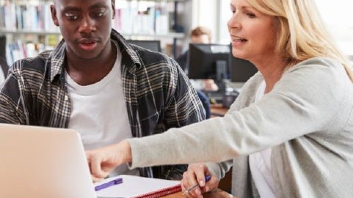 Adviser with student in library 