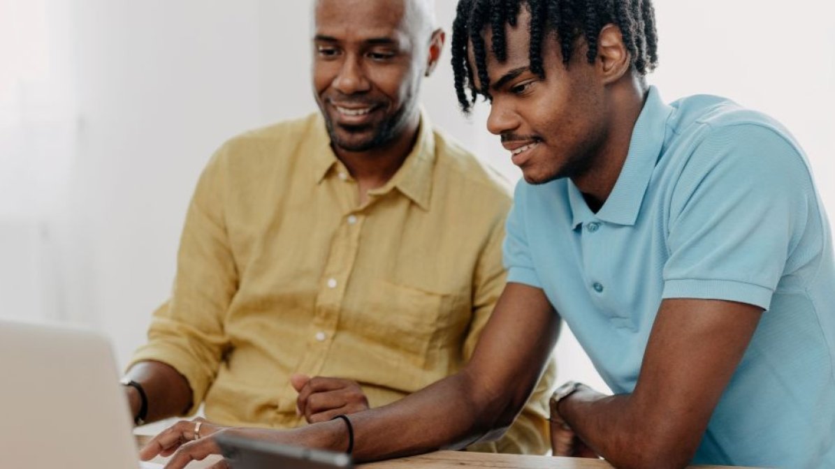 Parent and child researching higher education options on laptop