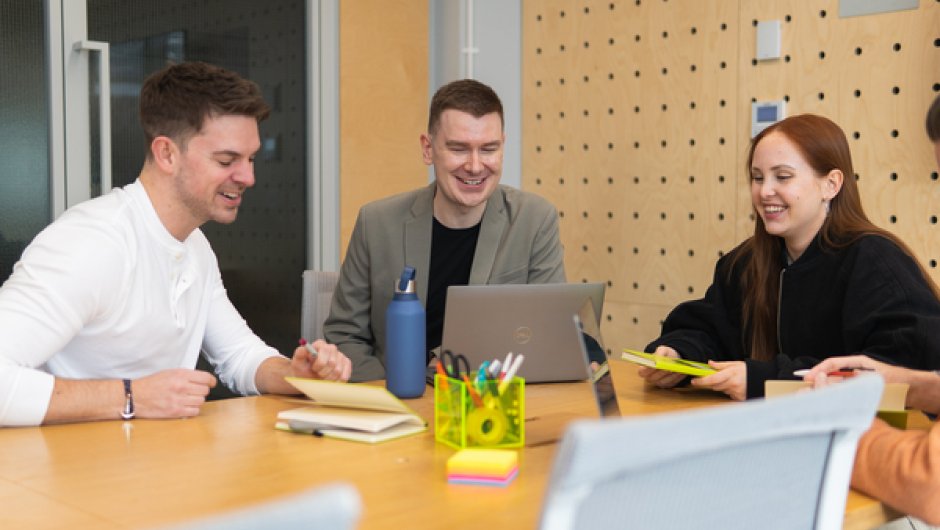 Apprentices around desk in work meeting