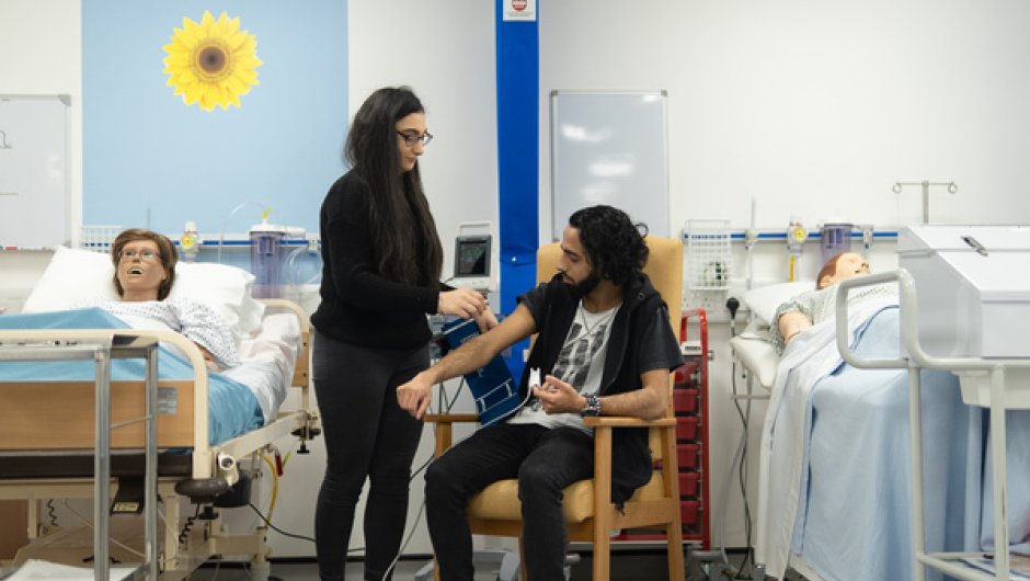 Medical student taking patient's blood pressure