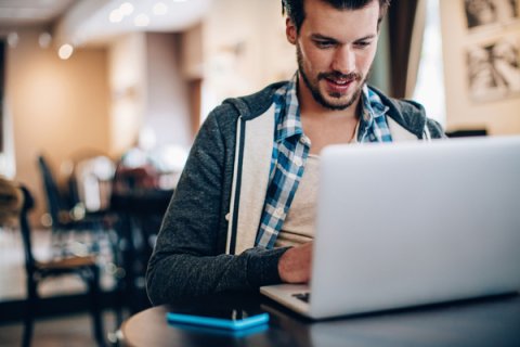 Disabled student using laptop to search for higher education funding