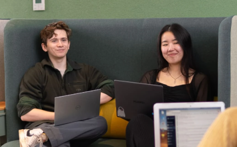 Students using laptops in communal area at university