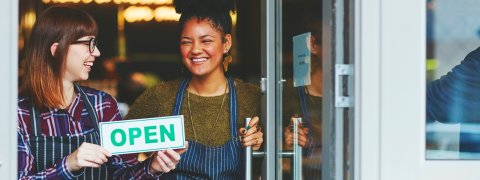 Two staff members opening their shop