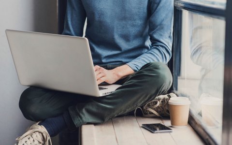 Student sat in the window using a laptop
