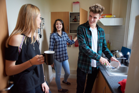 A group of students talking in a kitchen
