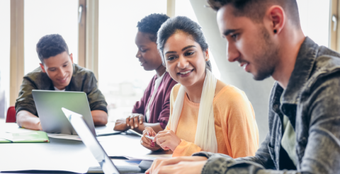 A photo of a group of students sitting working at their laptops