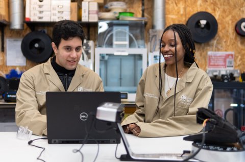 Apprentices working on laptop in a workshop 