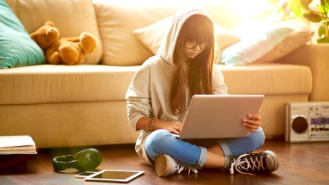 Student sat on floor with laptop
