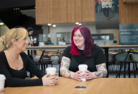 Students chatting over a drink in university canteen