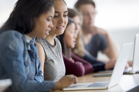 student typing on laptop