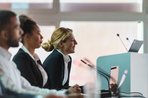 Three people speaking into microphones